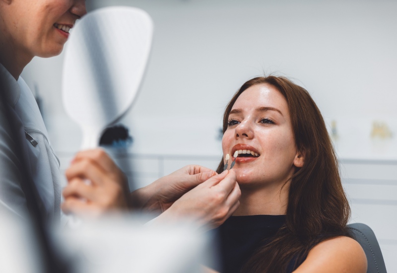 A dentist matching shades for a patient during a no-prep veneers consultation in Warrenville, IL